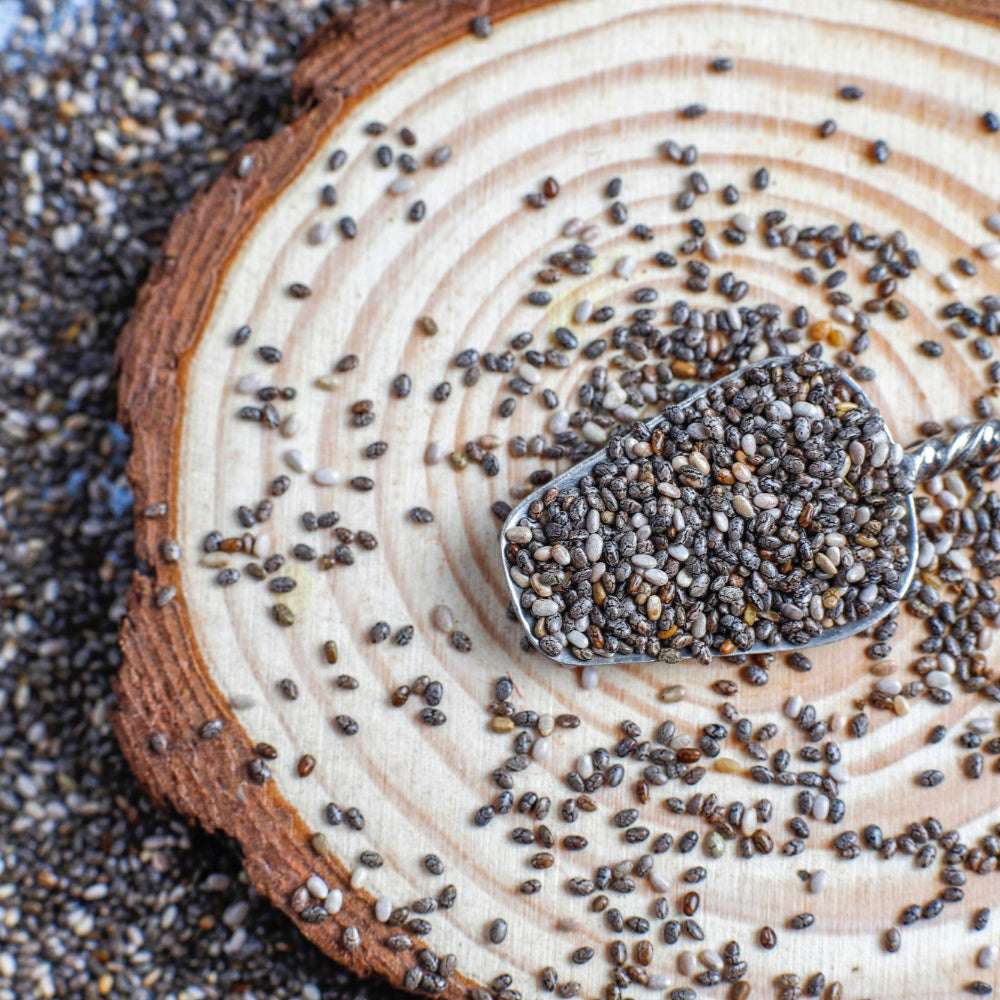 Chia seeds on a wooden surface with a spoon